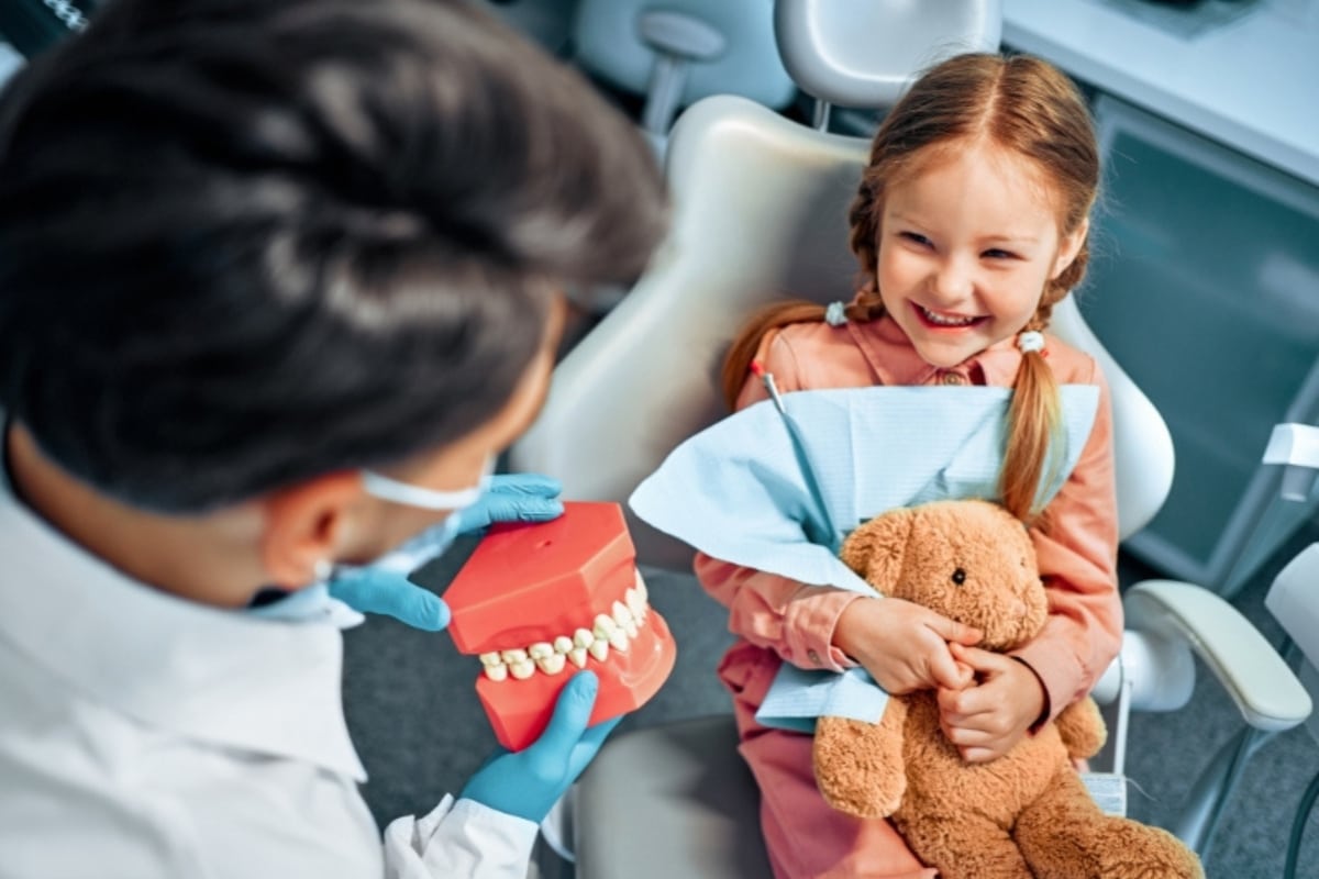Child smiling during a first dental visit with a pediatric dentist