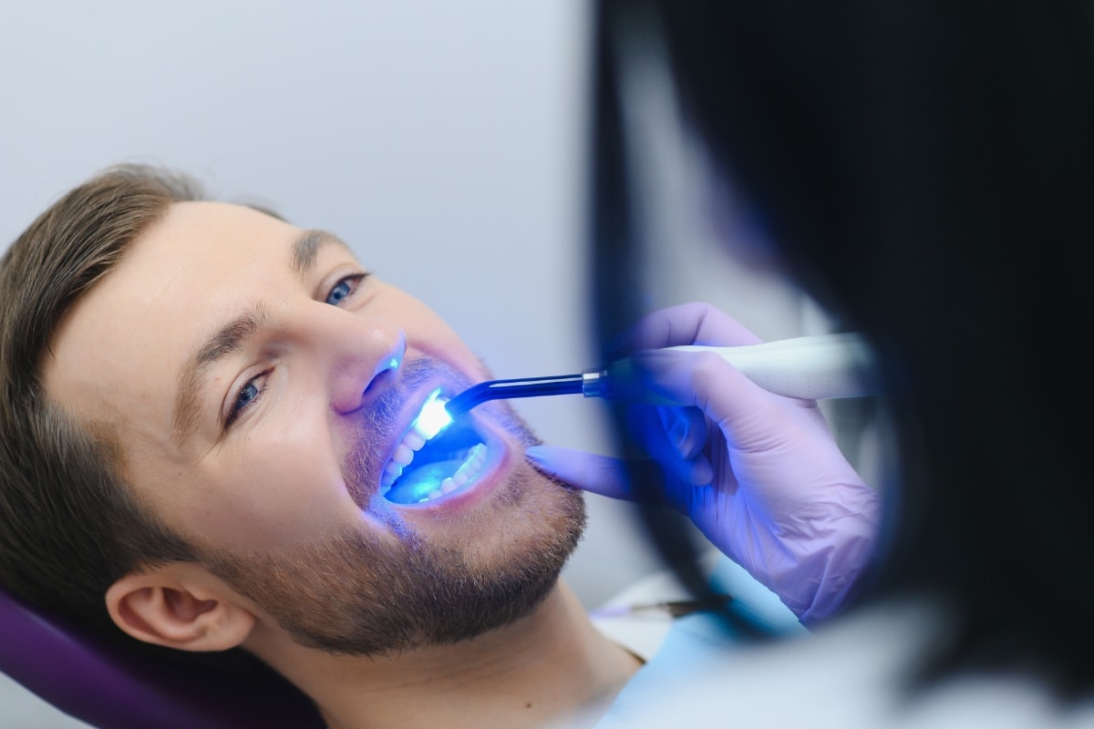 Dentist treating a patient for tooth sensitivity during a dental care visit.